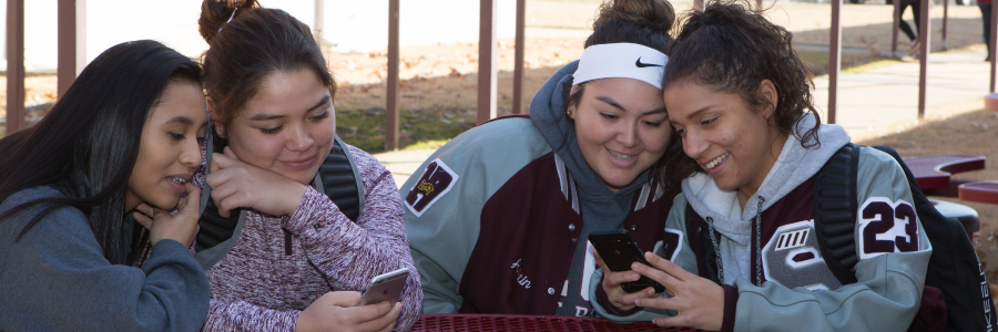 Students on their phones texting and looking at messages