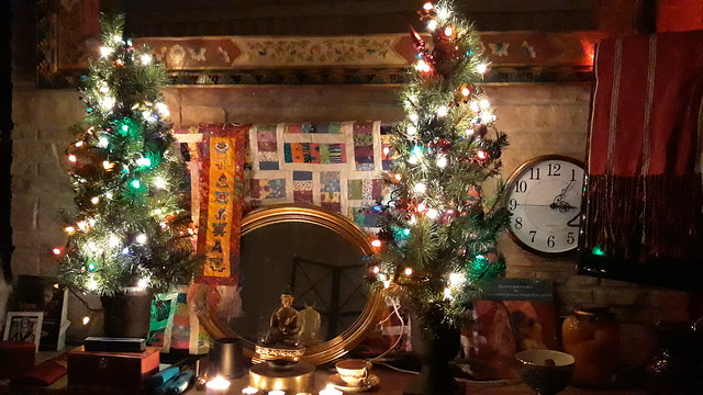 The Christmas Shrine, Buddha, offering of tea, mirror, lit trees, clock, mirror trim, prayer shawl, books, incense, lighters, offering bowl, candles, Impeachment peaches, Christmas season, Lakota Lhamo Ling, Washington, USA