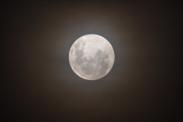 Glowing full moon in a smoky hazy night sky