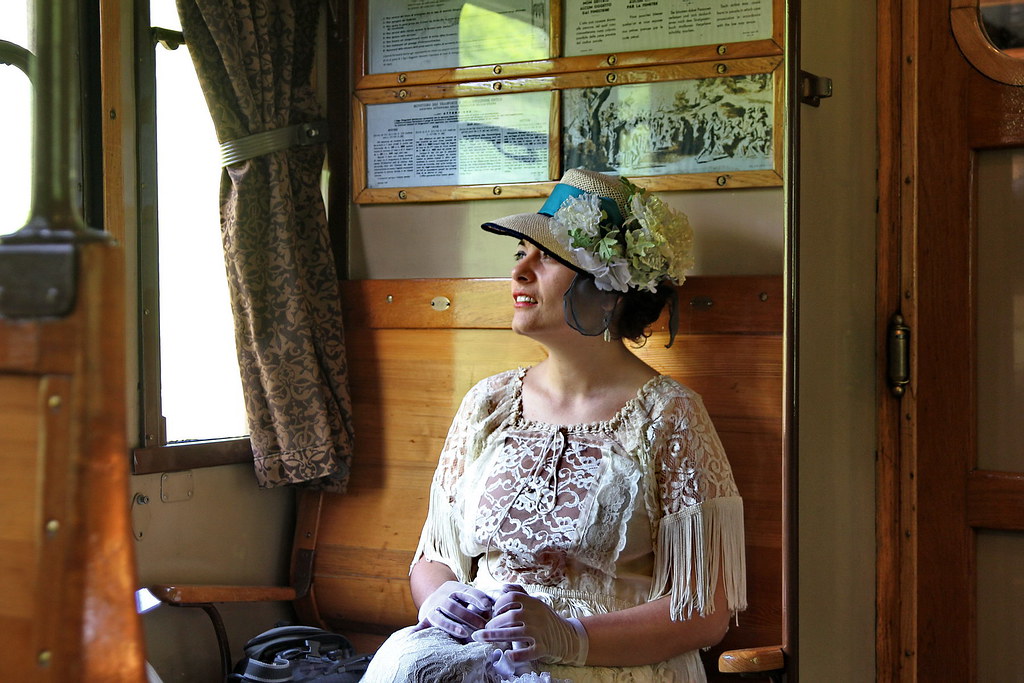 A lady traveling on an old train.