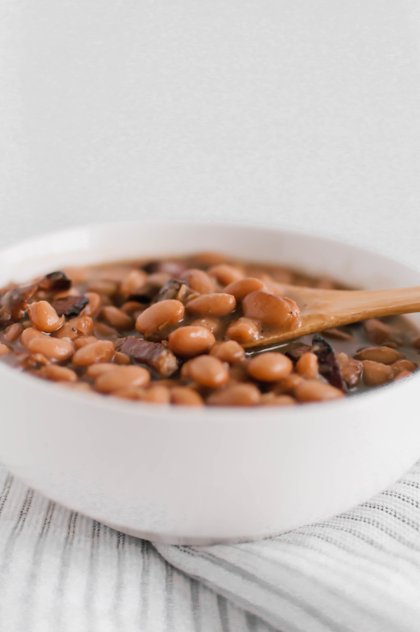 If you love Chipotle's pinto beans, look no further because now you can make them at home. Dried pinto beans cook all day in the slow cooker with bacon, onion and garlic to make these flavorful Bacon Pinto Beans. Perfect for rice bowls, nacho night or even on their own.