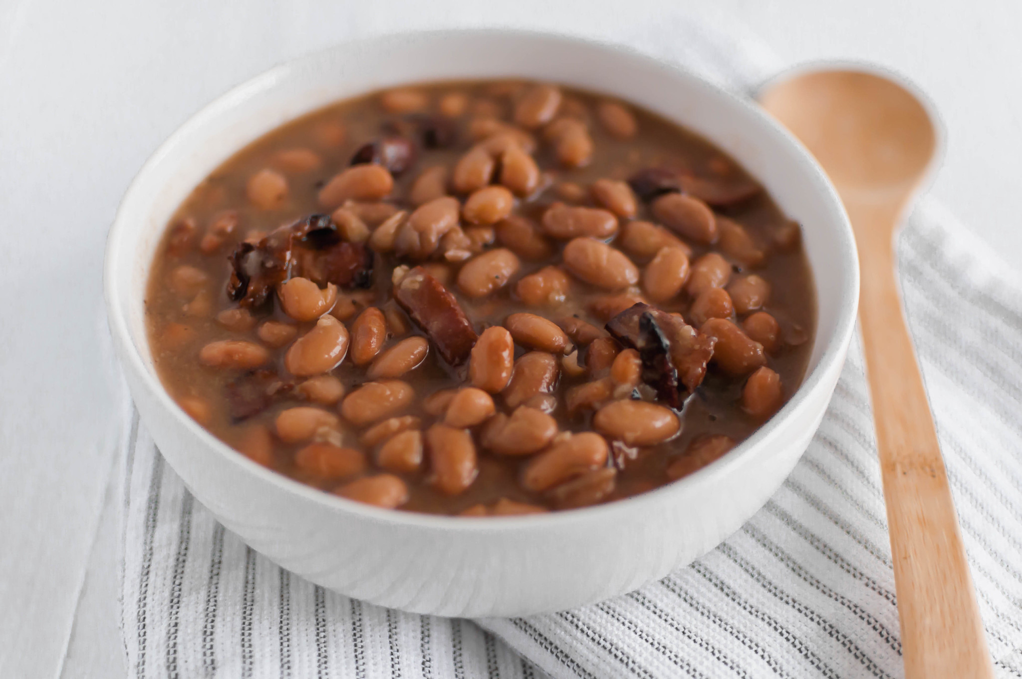 If you love Chipotle's pinto beans, look no further because now you can make them at home. Dried pinto beans cook all day in the slow cooker with bacon, onion and garlic to make these flavorful Bacon Pinto Beans. Perfect for rice bowls, nacho night or even on their own.
