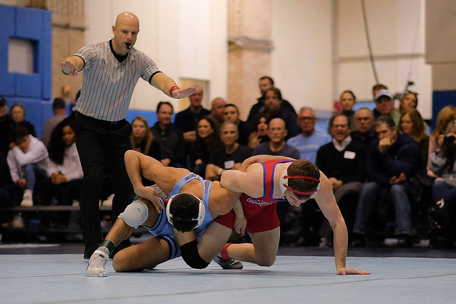 The American wrestler (red) uses a Whizzer to defend against the Columbia wrestler (blue)