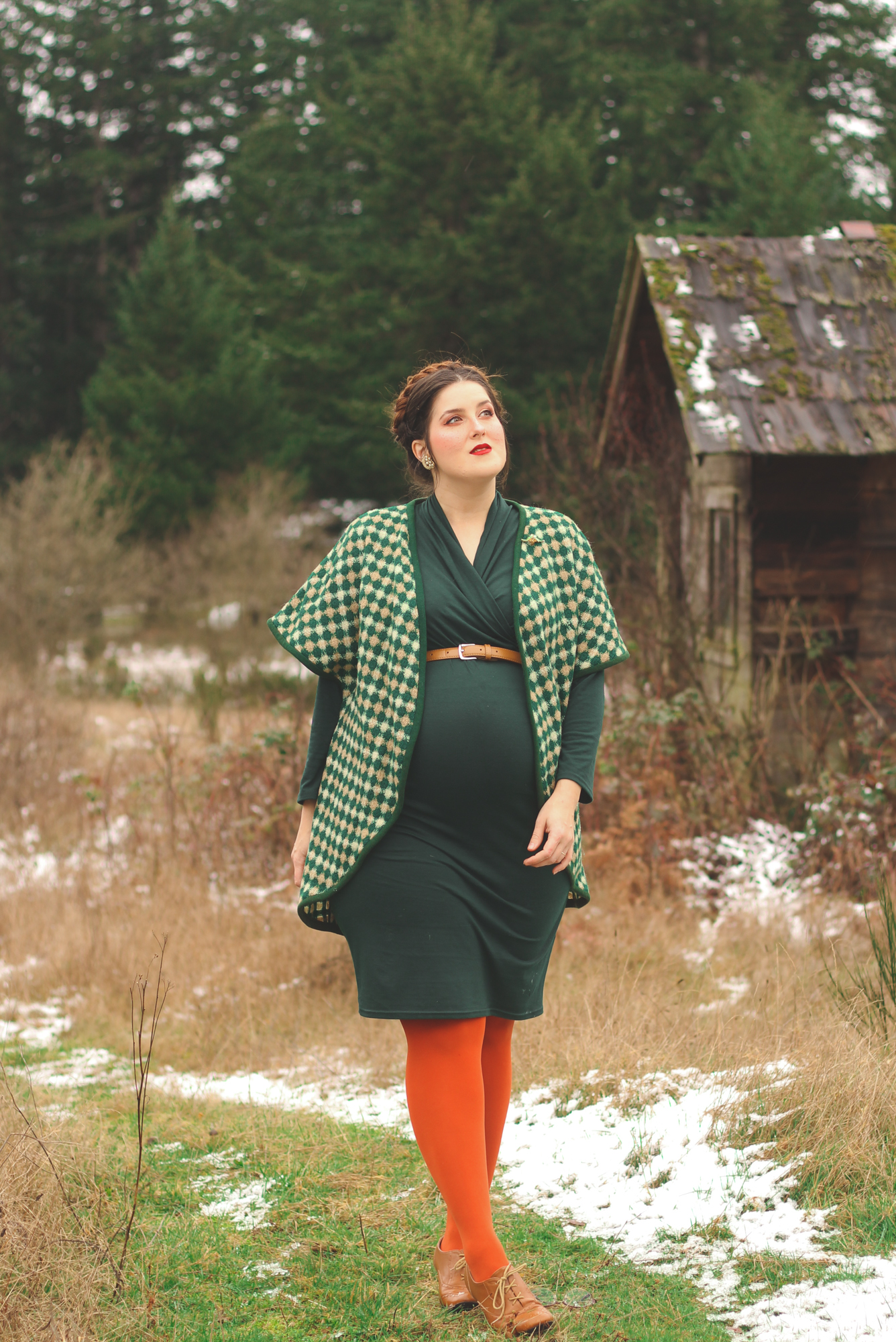 woman wearing green plaid and showing how to style maternity in the snow