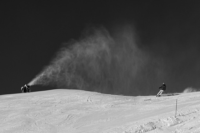 The skier below the snow cannon