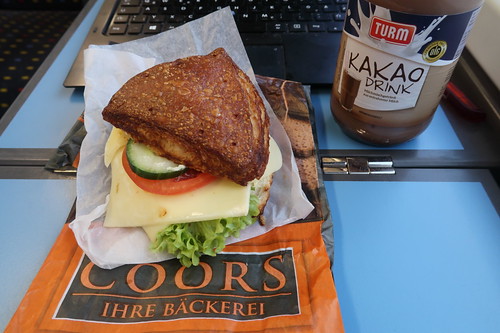 Vegetarisch belegte Laugenecke von der Bäckerei Coors (Osnabrück Hbf) mit Kakao Drink als Frühstück im Zug