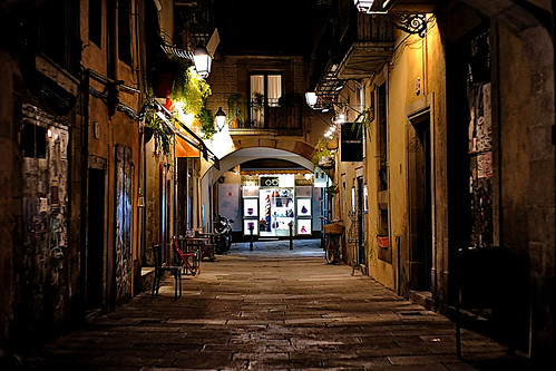 street alley callejón wall plant seat chair table store shop bike bicycle moto motorcycle vehicle door window balcony balconies balcón narrow light color colour colores colours colors barcelona lights reflection dusk atardecer night nightview nightshot outside outdoor