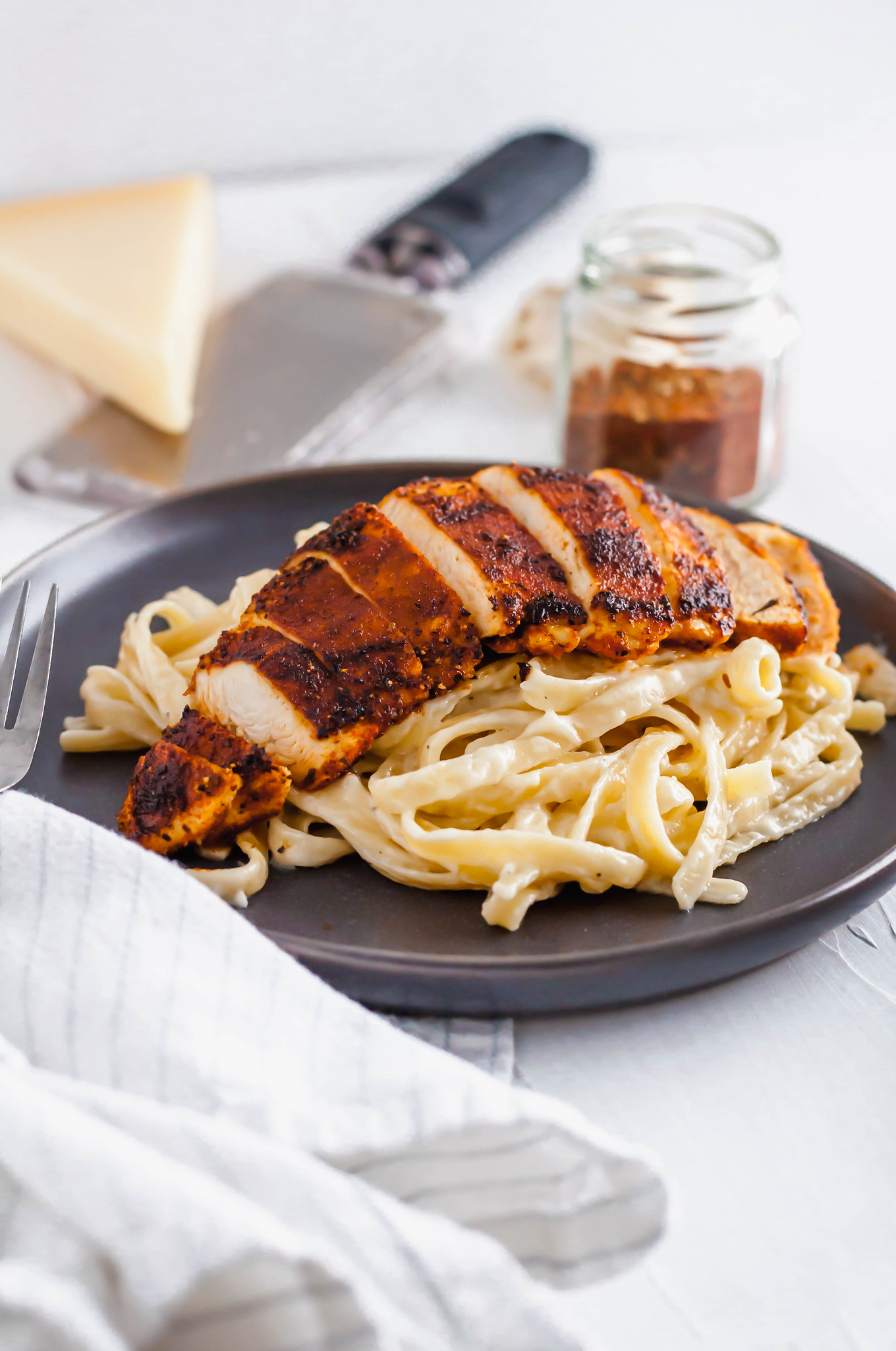 This Blackened Chicken Alfredo is the ultimate weeknight meal. Done in 30 minutes and packed with flavor. Easy enough for any weeknight but fancy enough for guests too. Homemade blackening seasoning covered tender chicken cutlets served over simple, cheesy homemade fettucine alfredo.