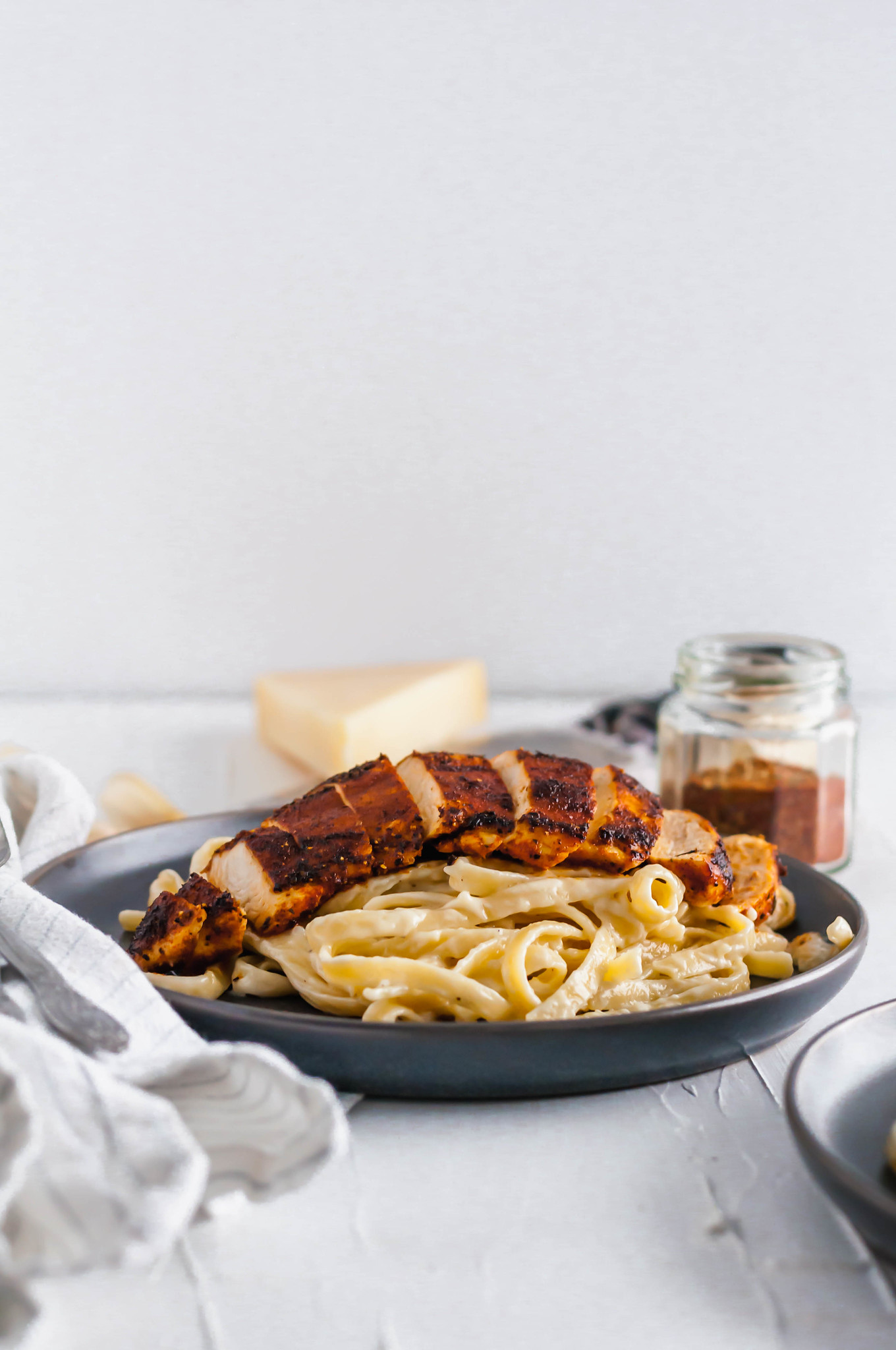 This Blackened Chicken Alfredo is the ultimate weeknight meal. Done in 30 minutes and packed with flavor. Easy enough for any weeknight but fancy enough for guests too. Homemade blackening seasoning covered tender chicken cutlets served over simple, cheesy homemade fettucine alfredo.