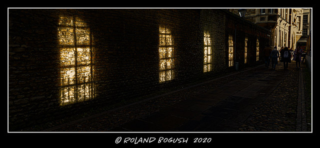 Borrowed light in the passage - sunlight streams through Senate House windows onto a wall on the far side of a public footpath.