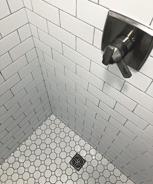 shower with classic subway tile and hexagon floor tile