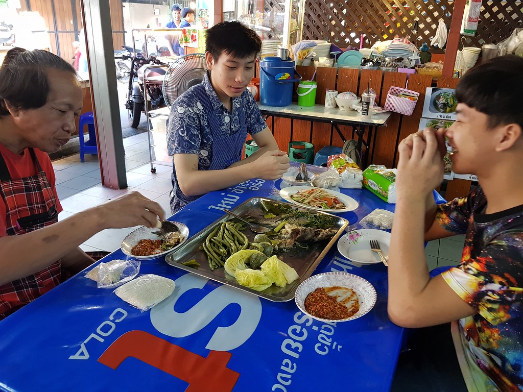 Thai hawkers workers having breakfast (fish, salad..) @ KafeSud in Muang Thai - Phatra morning Market, Bangkok Thailand