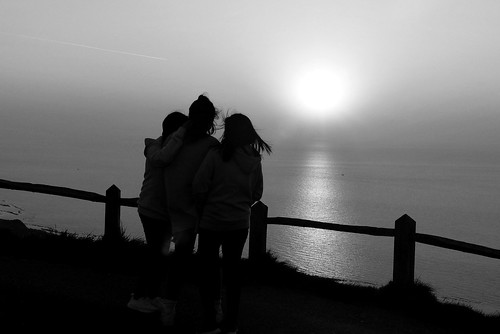 Three girls looking out to sea