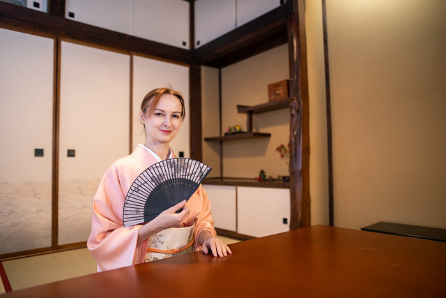 Russian woman in kimono sitting in Japanese tatami room, holding Sensu