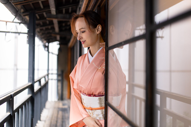 Russian woman in kimono looking outside from balcony in old Japanese house