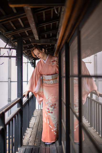 Russian woman in kimono standing on balcony of old Japanese house