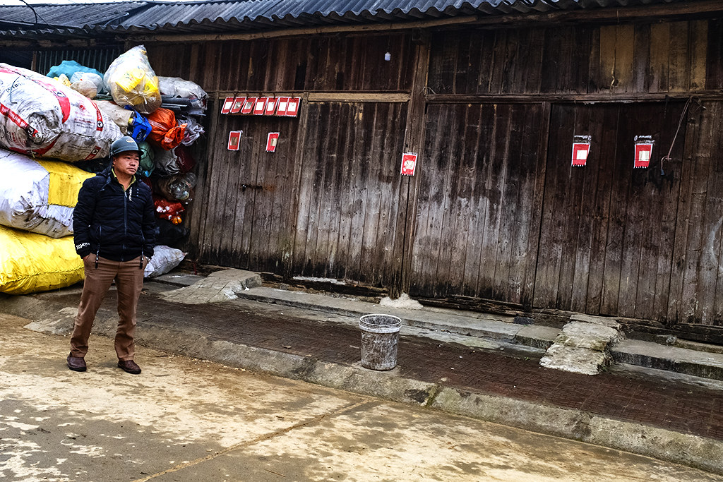Man in front of Hmong wooden house--Si Ma Cai