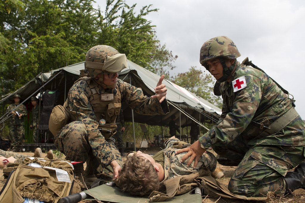 A Navy Sailor and Royal Thai sailor are participating in a mass casualty evacuation drill during exercise Cobra Gold 2020.