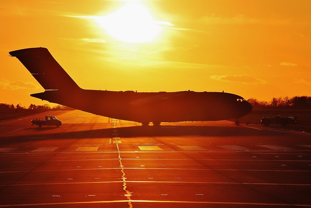 RAF Brize Norton C17 on tow across the runway at sunset .