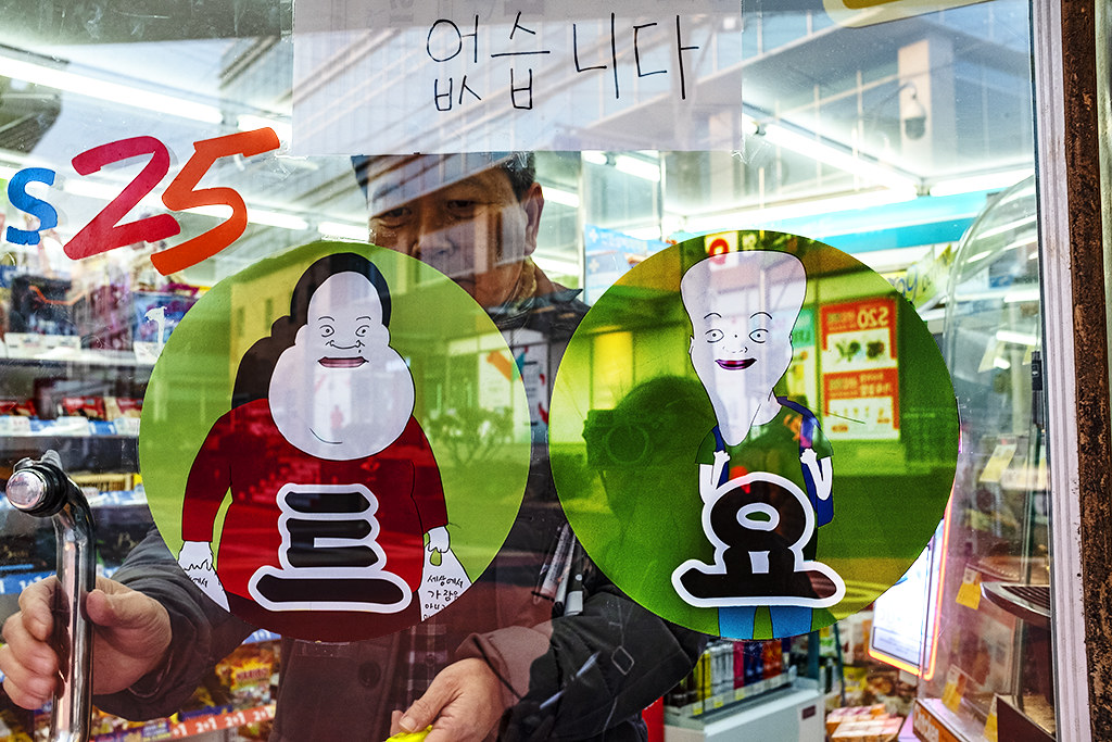 Grotesque cartoon figures on convenience store's door--Seoul