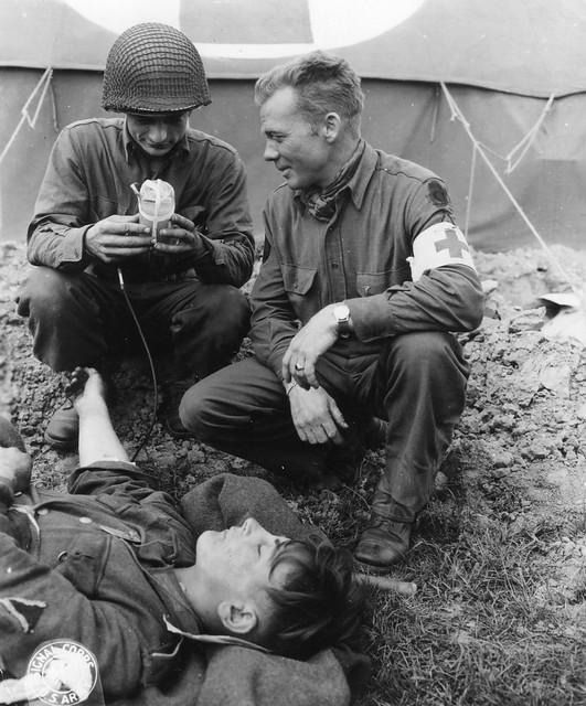 SC 190593 - U.S. medics giving blood plasma to a wounded German soldier. St. Mere Eglise, Normandy, 15 June, 1944.