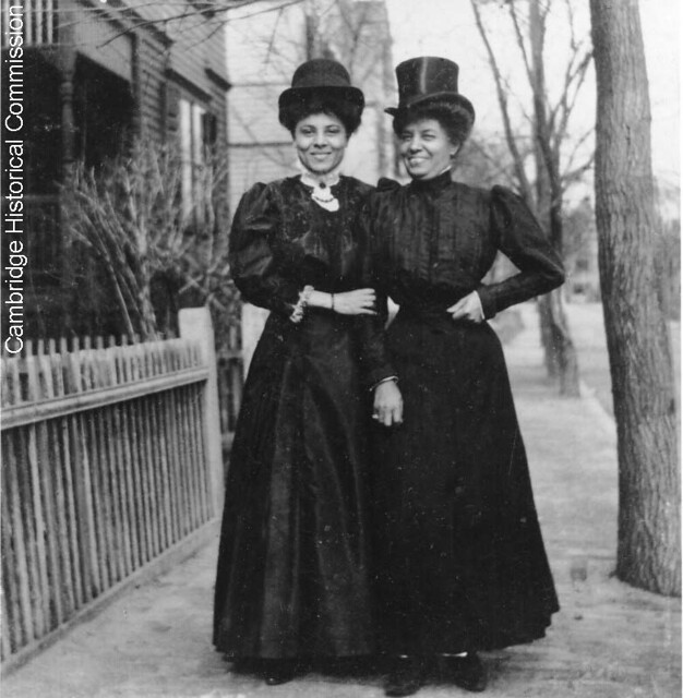 Two women in black and tophats