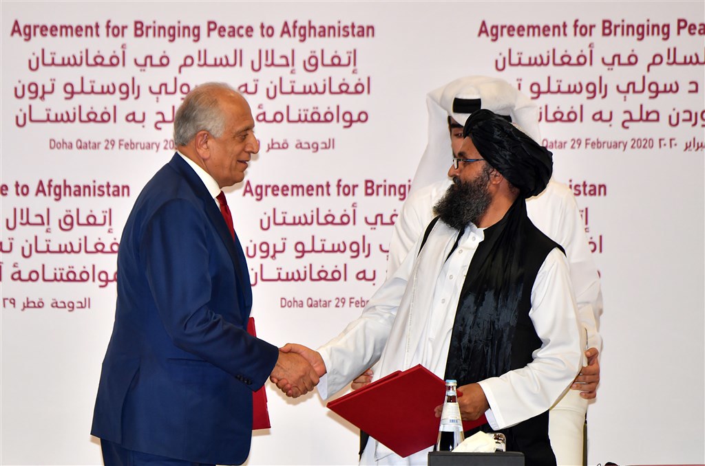 塔利班第二號領袖巴拉達（右）與美國阿富汗和解問題特別代表哈利勒扎德（左）簽署和平協議。（圖片來源：法新社）