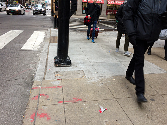 People walking by origami trash