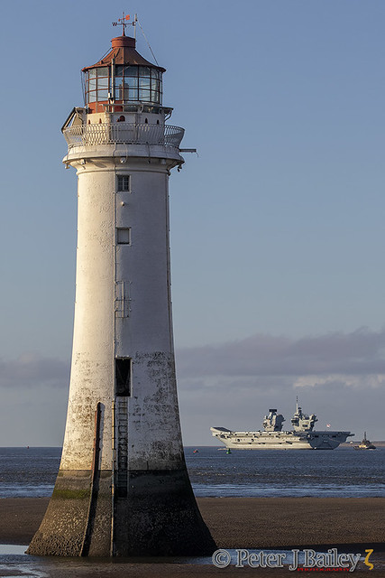 HMS Prince of Wales (R09), Queen Elizabeth-class aircraft carrier departing from Liverpool passing Perch Rock lighthouse.