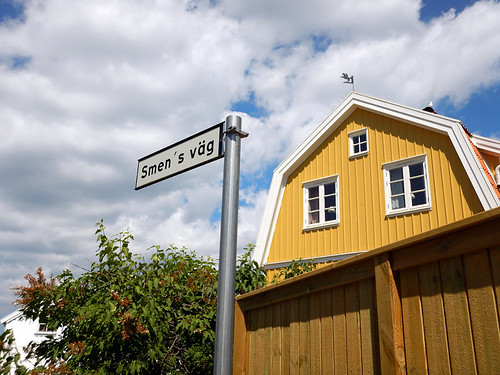 Yellow house with road sign in Fiskebackskil harbour on Bohuslan Coast of Sweden