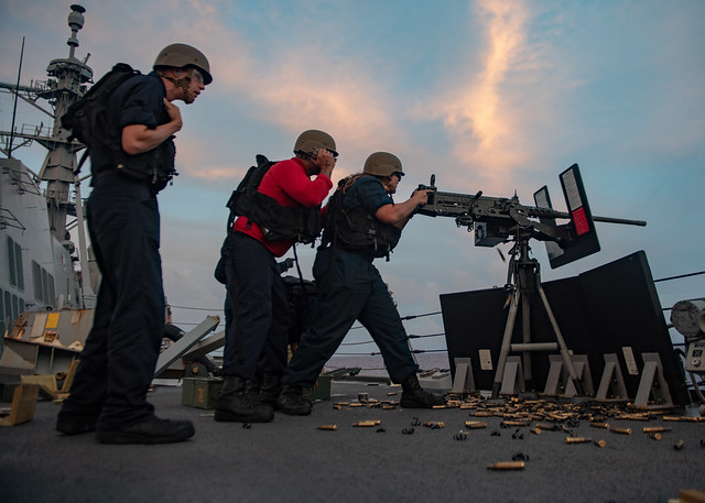 Sailors aboard USS Mustin (DDG 89) fire a .50-caliber machine gun during a live-fire exercise.