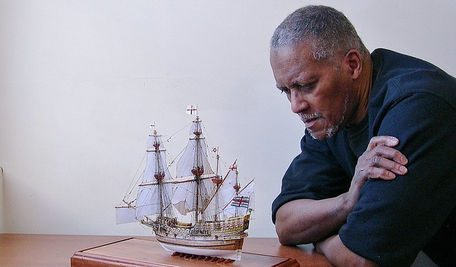 American artist-craftsman Rex Stewart inspecting miniature of the English galleon REVENGE.