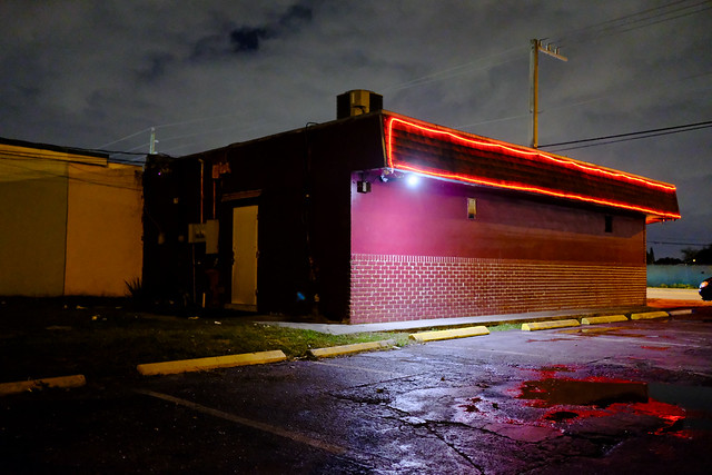 Moody nightclub bar with red neon lights at night