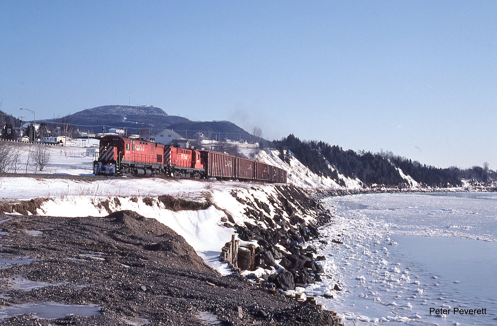 New Brunswick East Coast Train 595 with C-424 # 4214, RS-18 # 1854 run alongside Chaleur Bay at Carleton, Quebec Feb. 10, 2006. The train is back hauling wood chips from the closed New Richmond mill.