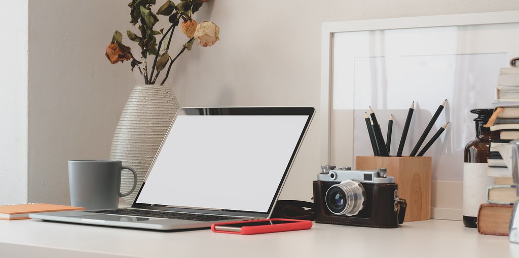 Appareil photo analogique derrière un ordinateur portable - Crédit à https://homegets.com/
