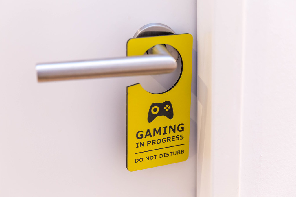 A gamer's room: white door with yellow \