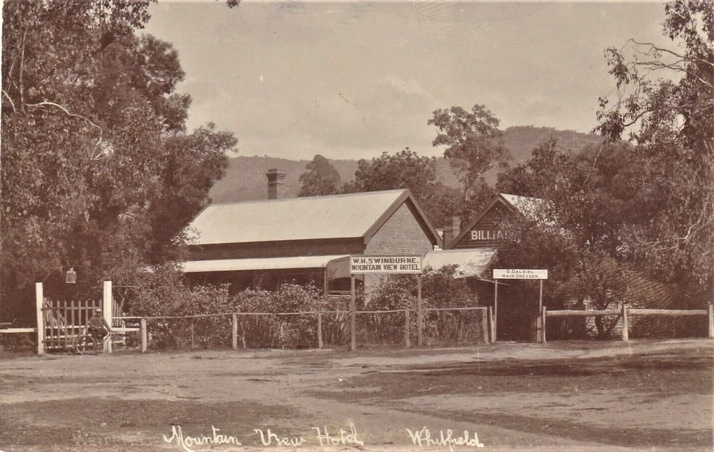 Sepia postcard of the Mountain View Hotel in Whitfield, Victoria, before 1916, a brick pub behind a timber fence with forested hills behind, by Aussie~mobs, on Flickr