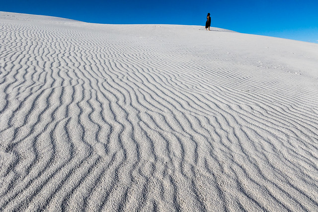 Gypsum sand dune with woman in black