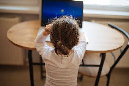 Kind sitzt am Computer. Fernunterricht während der Coronavirus Pandemie | by Ivan Radic