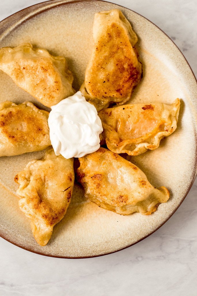 Easy homemade pierogies filled with two different fillings including cheddar mashed potato and caramelized onions with sauerkraut.