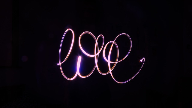 Isolated pink light painting of the handwritten word 'love'
