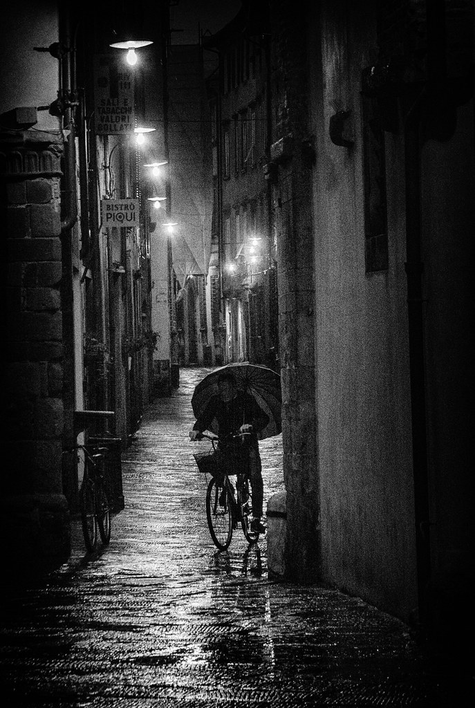 street photography Italy cyclist with umbrella