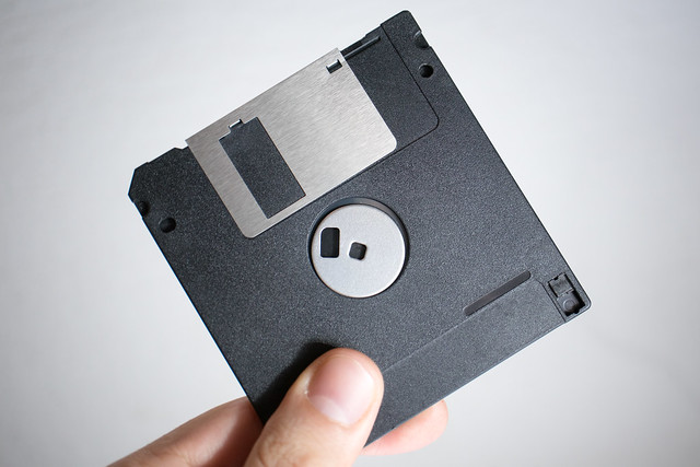 Man holding a floppy disk in hand. Giving away and leaking sensitive data