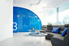 Modern office with cozy lobby furnished with sofa and coffee tables, interior with blue elements