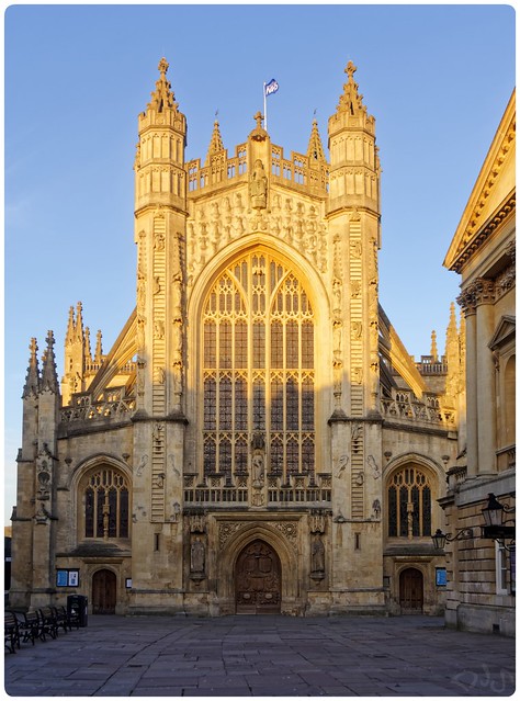 Bath Abbey West Front at golden hour with NHS flag
