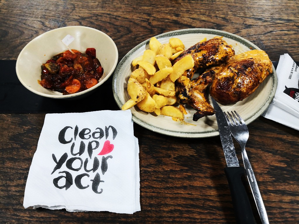 Half chicken with sides of potato wedges and vegetables at Nando's Johannesburg OR Tambo International Airport
