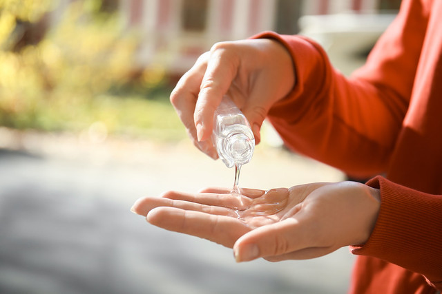 Woman using hand gel outdoors