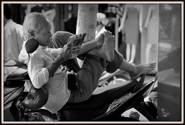Pour lire le journal , se nettoyer entre les orteils en equilibre sur une motorbike aussi facilement , il faut faire preuve d'une sacrée dextérité.Rue de Saigon.