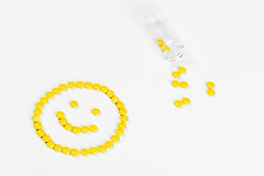 A smile made of yellow pills on a white background