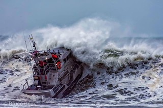 Petty Officer 1st Class Adam Preiser (surfman #535) operates a 47-foot Motor Lifeboat in the surf near Brookings, Oregon. (U.S. Coast Guard photo courtesy of Bruce Beck Photography Public Domain use approved by Mr. Bruce Beck) 
